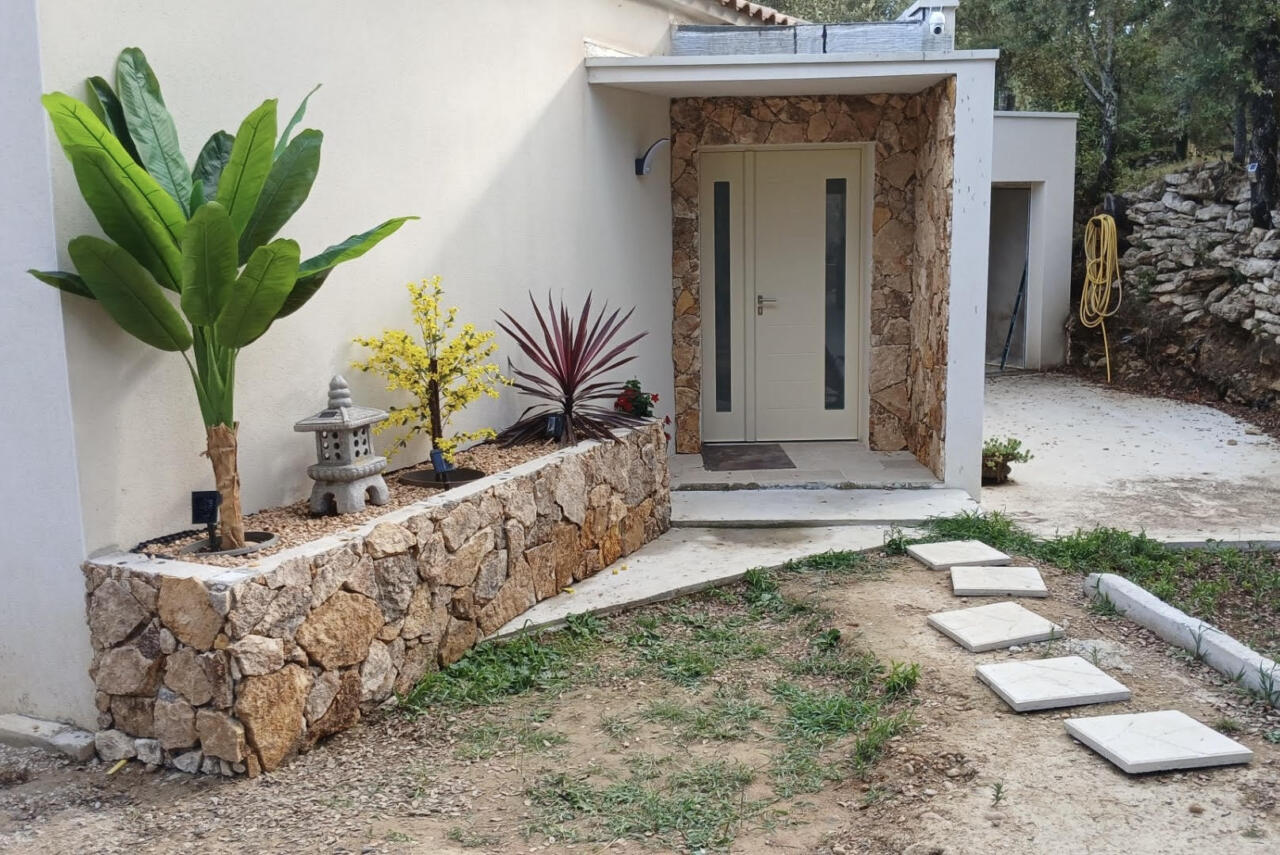 Parement pierre jardinière et entourage de porte d'entrée de maison