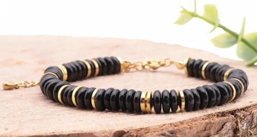 BRACELET ONA DORÉ ONYX A Référence : 3701459098736 Couleur : Doré - Noir Taille du bracelet : 17 à 23cm Diamètre des perles : 06mm Métal : Acier Inoxydable *Afin de préserver vos bijoux, ne pas mettre en contact avec l’eau.