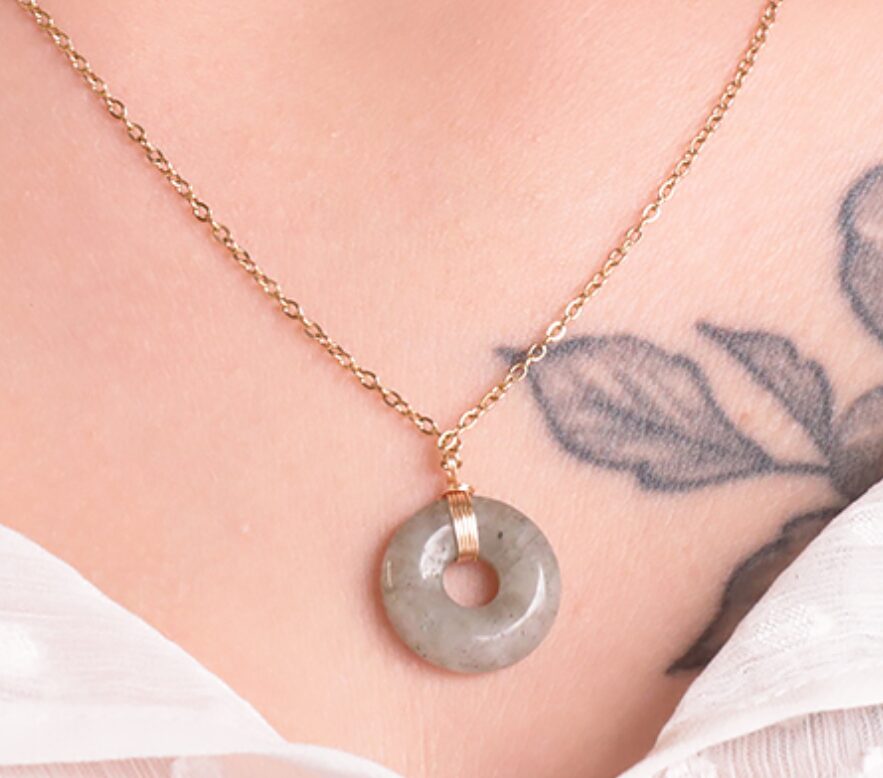 COLLIER LOA DORÉ LABRADORITE A Référence : 3701459098217 Pierre(s) : Labradorite - Couleur : Doré - Gris - Reflets Taille du collier : 48 à 53cm Dimamètre donut : 17mm Métal : Acier Inoxydable *Afin de préserver vos bijoux, ne pas mettre en contact avec l’eau.