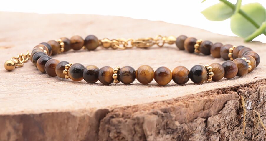 BRACELET HALO DORÉ OEIL DE TIGRE A Référence : 3701459098453 Couleur : Doré - Marron - Noir Taille du bracelet : 17 à 23cm Diamètre des perles : 04mm Métal : Acier Inoxydable *Afin de préserver vos bijoux, ne pas mettre en contact avec l’eau.